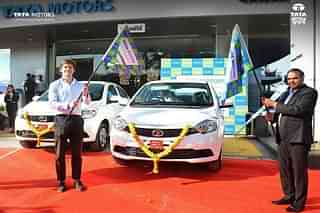 Tata Motors Executive Shailesh Chandra (R) and Zoomcar CEO Greg Moran (L) flagging off the electric vehicles in Pune. (@TataMotors/Twitter)