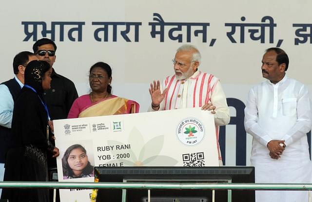  Prime Minister Narendra Modi gives a health card to beneficiaries as he launches Ayushman Bharat-National Health Protection Scheme on September 23, 2018 in Ranchi. (Photo by Parwaz Khan/Hindustan Times via Getty Images)