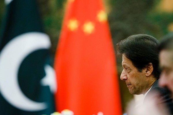 Pak PM, Imran Khan with a Chinese flag in the backdrop. (Thomas Peter-Pool/Getty Images)