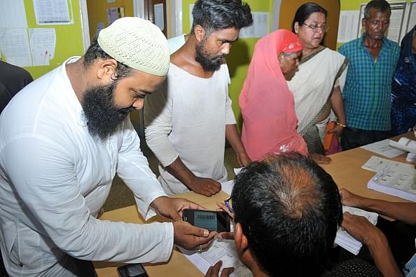 People checking their names in the draft NRC at a Seva Kendra. (Photo by Rajib Jyoti Sarma/Hindustan Times via Getty Images)