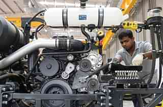 A worker assembles a bus at a manufacturing facility in Bengaluru. (MANJUNATH KIRAN/AFP/GettyImages)