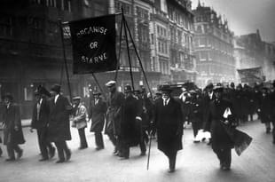 Unemployed men marching along the Thames embankment, carrying a banner reading ‘Organise or Starve’. (Topical Press Agency/Getty Images)