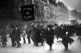 Unemployed men marching along the Thames embankment, carrying a banner reading ‘Organise or Starve’. (Topical Press Agency/Getty Images)