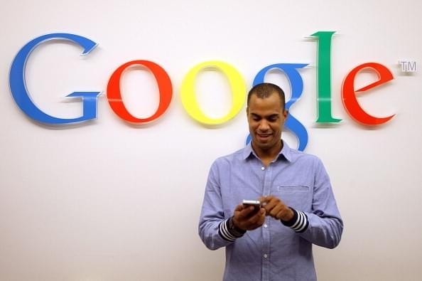 A man using a smartphone in front of the Google logo at the company’s offices in Berlin (Representative image) (Adam Berry/Getty Images)