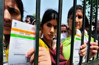 Women with their Aadhaar cards at a government camp in New Delhi. (Priyanka Parashar/Mint via GettyImages)