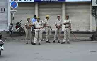 Police personnel next to closed shops in Jaipur. (Photo by Himanshu Vyas/Hindustan Times via Getty Images)