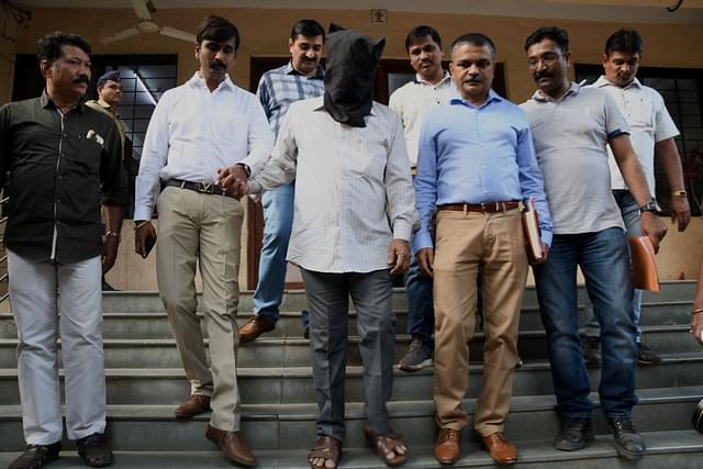 One of the suspects being whisked away (Photo by Praful Gangurde/ Hindustan Times via Getty Images)