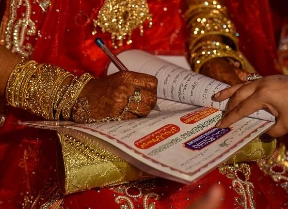 A woman signs a Nikah Nama in Bhopal. (Photo by Kunal Patil/Hindustan Times via Getty Images) 