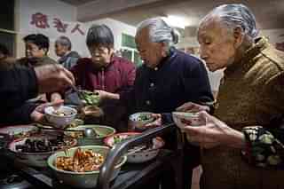 Aged Chinese citizens receive meals at a temple. (Photo by Kevin Frayer/Getty Images)
