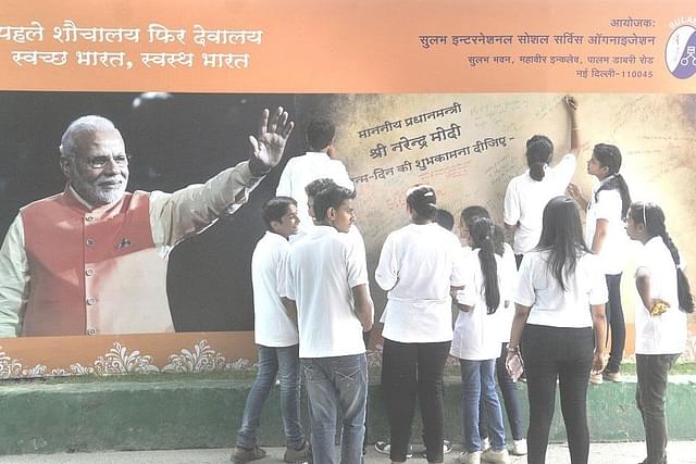 School children writing the messages on the poster put up to celebrate the 65th birthday of Narendra Modi at FICCI Auditorium on 17 September, 2015 in New Delhi (Sushil Kumar/Hindustan Times via GettyImages)
