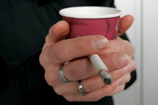 A smoker enjoys a cigarette and a coffee outside an office building (Ralph Orlowski/Getty Images)