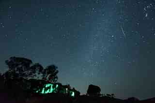 A meteor streaks across the night sky during the Geminid Meteor Shower over Harishchandra Fort on December 15, 2018 in Ahmednagar. (Photo by Pratik Chorge/Hindustan Times via Getty Images)