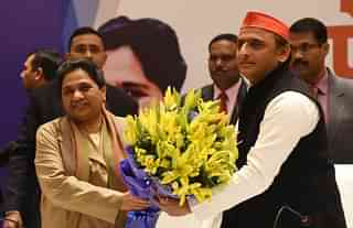 Samajwadi Party president Akhilesh Yadav presents a bouquet to Bahujan Samaj Party chief Mayawati during a joint press conference in Lucknow. (Subhankar Chakraborty/Hindustan Times via GettyImages)&nbsp;