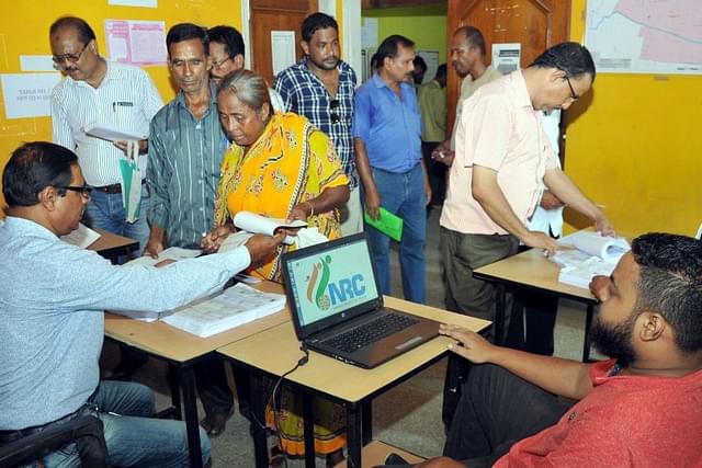People check their name on the final draft list of the state’s NRC list at NRC Seva Kendra at Hatigaon on July 30, 2018 in Guwahati. (Photo by Rajib Jyoti Sarma/Hindustan Times via GettyImages)