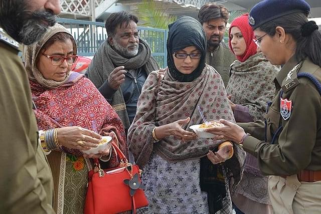 Punjab Police personnel distribute food to Pakistani passengers stranded outside Attari Railway station near Amritsar after train services were suspended (representative image) (pic via Twitter)