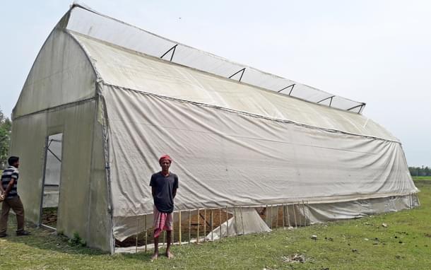 Sudhir Roy Sarkar in front of the greenhouse where he now stores paddy husk (Credit: Abir Bhattacharjee)
