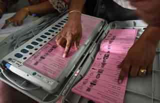 A polling staff tallies the candidates’ names on the electronic voting machines. (Arijit Sen/Hindustan Times via Getty Images)
