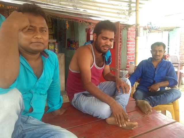 Three men from the Yadav community sitting outside a small kirana shop along the town’s main road in Mehnagar’s Gaura village. (Prakhar Gupta/Swarajya)
