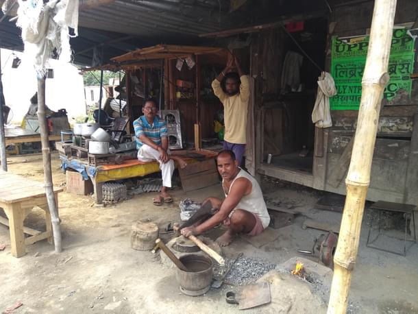 Inderdev Vishwakarma working outside his iron workshop. Veeru Kumar (right) and Jitender Singh in the background. (Prakhar Gupta/Swarajya Magazine)