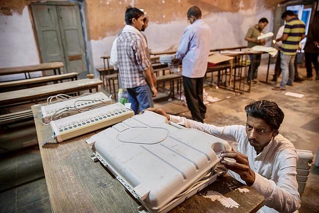 An election worker closes up an EVM before sealing it. (Kevin Frayer/GettyImages)