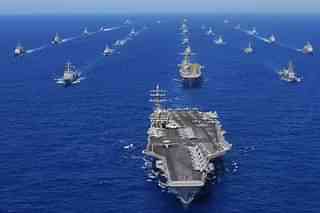 US Navy ships being headed by an aircraft carrier.