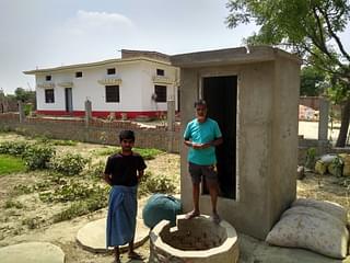 Rajender and Jaisingh Yadav standing in front of&nbsp; an under-construction toilet in Tamauli. (Prakhar Gupta/Swarajya)