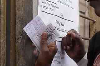 An elector shows his voter ID at a polling booth in Bengaluru. (Flickr)
