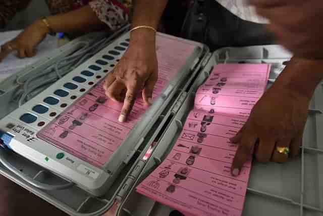 A polling staff tallies the candidates’ names on the Electronic Voting Machines (EVM) (Arijit Sen/Hindustan Times via Getty Images)