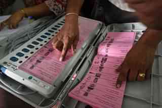 A polling staff tallies the candidates’ names on the Electronic Voting Machines (EVM) (Arijit Sen/Hindustan Times via Getty Images)