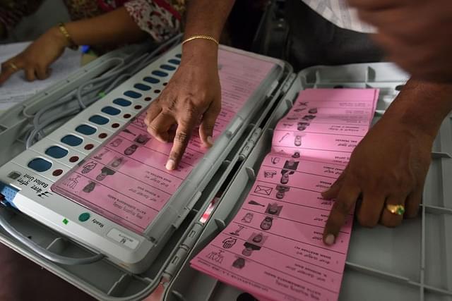 A polling staff tallies the candidates’ names on the Electronic Voting Machines (EVM) (Arijit Sen/Hindustan Times via Getty Images)