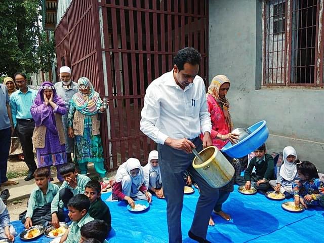 An officer serving mid-day meals to the school children in shamsipora village of Shopian during his visit as a part of “back to village” programme (Source: @Shopiankmr/Twitter)