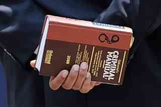 A lawyer holds a criminal manual (INDRANIL MUKHERJEE/AFP/Getty Images).