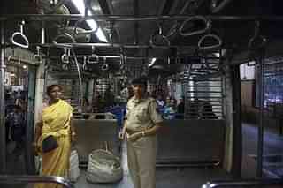 A policewoman checking an all-woman's coach for transgressions by males.  