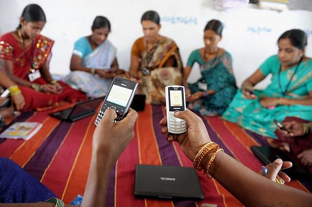 Indian villagers, part of a Self Help Group (SHG) organisation, pose with mobile phones and laptops in Bibinagar village outskirts of Hyderabad on March 7, 2013, on the eve of International Women’s day. (NOAH SEELAM/AFP/Getty Images)