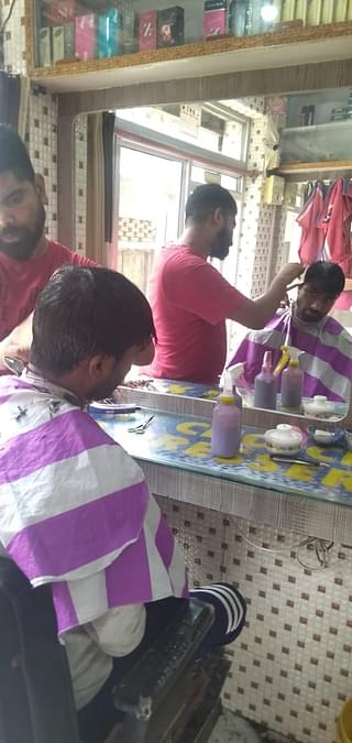 Riyaz Alam giving haircut to a customer from Valmiki community