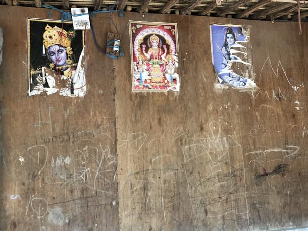 Pictures of gods and goddesses stuck on the wall of a house.