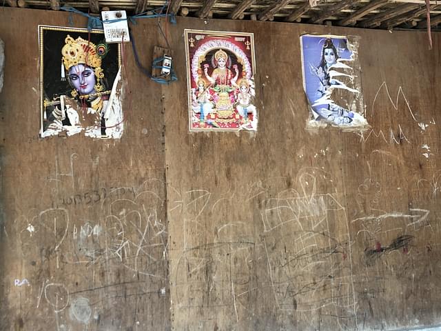 Pictures of gods and goddesses stuck on the wall of a house.