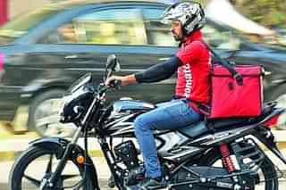 A Zomato delivery boy on a motorcycle.