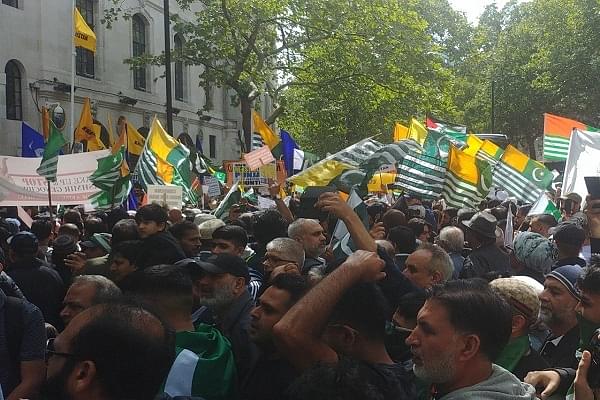 Demonstrators outside the Indian mission with Pakistani and PoK flags. (Pic via Twitter)