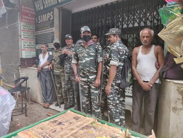CRPF personnel take shelter during rain in Delhi’s Lal Kuan on 13 August.