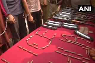 The arrested terrorists along with the weapons seized from them.