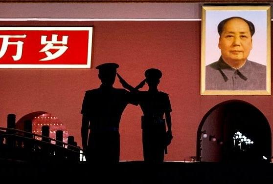 Chinese soldiers salute near Mao’s portrait in 2014 (Kevin Frayer/Getty Images)