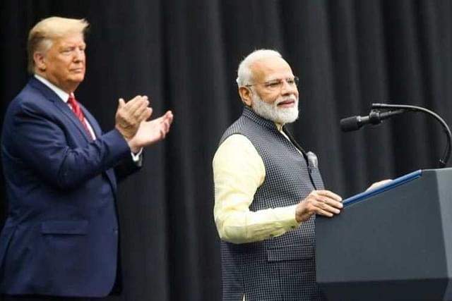 US President Donald Trump applauds as Prime Minister Narendra Modi addresses the Houston event.