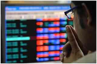 An investor looking at a screen displaying stocks.&nbsp;