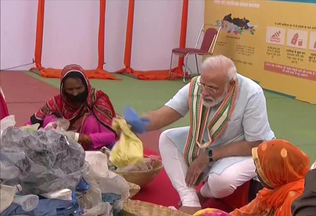 PM Narendra Modi sorts plastic waste with women who pick plastic from garbage (Source: @ANI/Twitter)