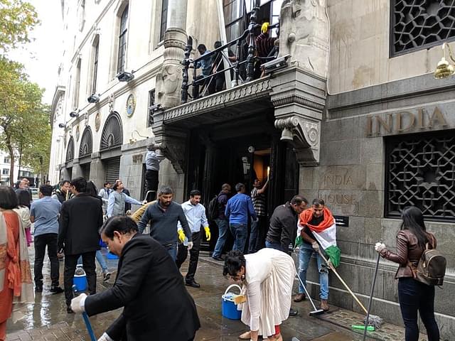 Diaspora volunteers wash the floors outside the high commission.
