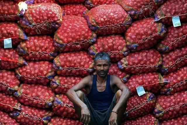 A labourer takes a break from unloading sacks of onions from a truck. (Representative Image )(Sanjay Kanojia/AFP/Getty Images)