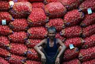 A labourer takes a break from unloading sacks of onions from a truck. (Sanjay Kanojia/AFP/Getty Images)