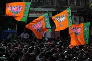 BJP supporters raise party flags.