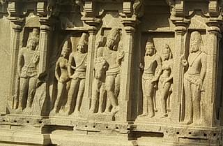 Siva, as Rishabantika, on the wall of Arjuna Ratham, leaning on a bull, flanked by royal couples, and dvarapalakas.